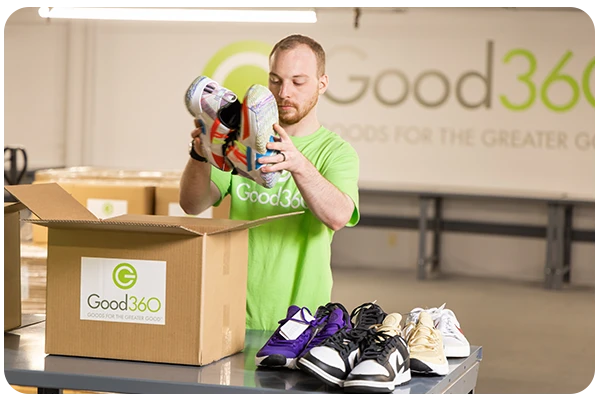A good360 volunteer packaging donated shoes.